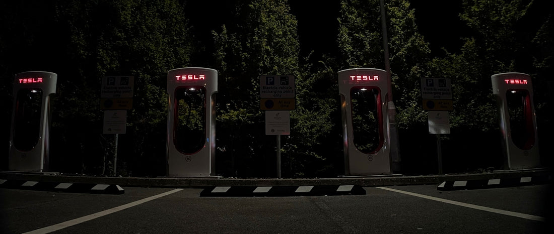 a row of gas pumps in a parking lot at night